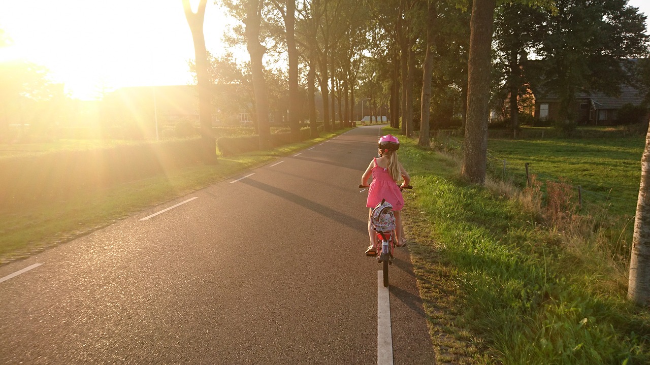 CC0 via Needpix -- https://www.needpix.com/photo/910540/girl-riding-bicycle-school-ride-happy-sport-fun-people